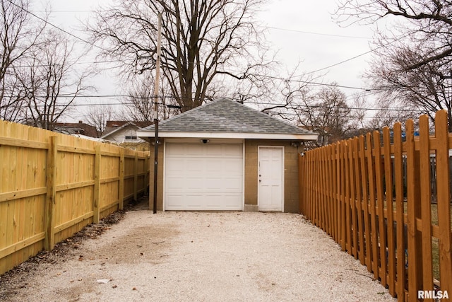 detached garage with fence and driveway
