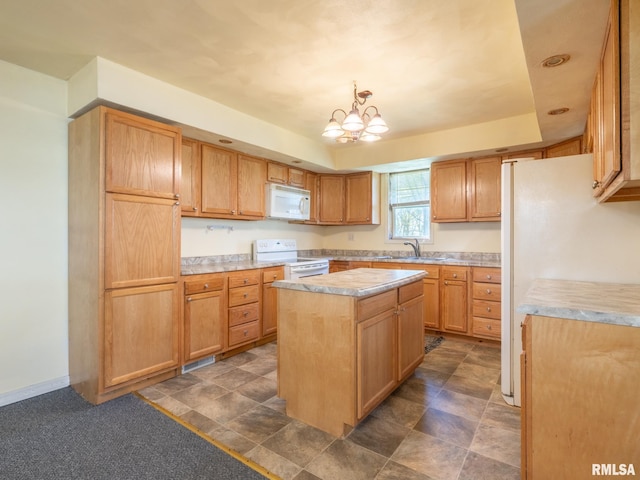 kitchen featuring white appliances, light countertops, a sink, a center island, and a notable chandelier