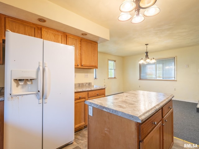 kitchen with white fridge with ice dispenser, brown cabinetry, an inviting chandelier, and light countertops