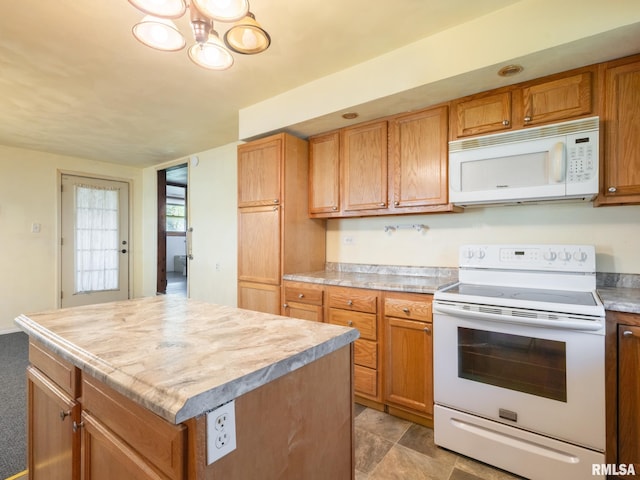 kitchen featuring white appliances, light countertops, and a kitchen island