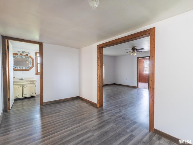 empty room featuring dark wood-style flooring, ceiling fan, and baseboards