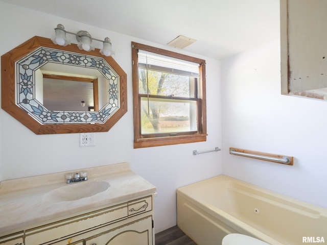 bathroom with visible vents, a whirlpool tub, and vanity