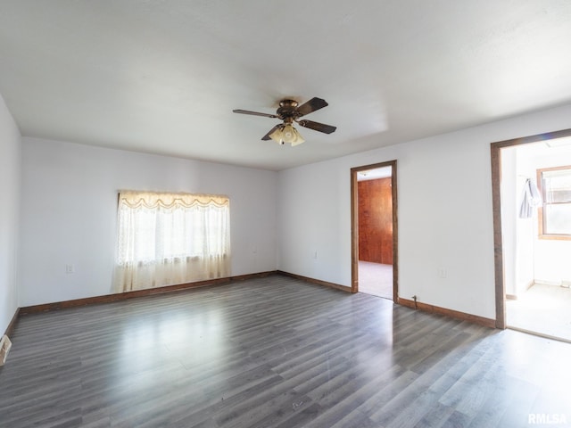empty room with a ceiling fan, wood finished floors, and baseboards