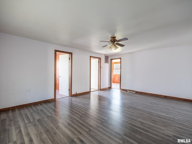 empty room featuring baseboards, visible vents, wood finished floors, and a ceiling fan
