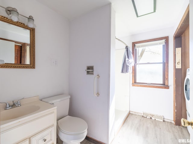 bathroom featuring wood finished floors, walk in shower, toilet, vanity, and visible vents