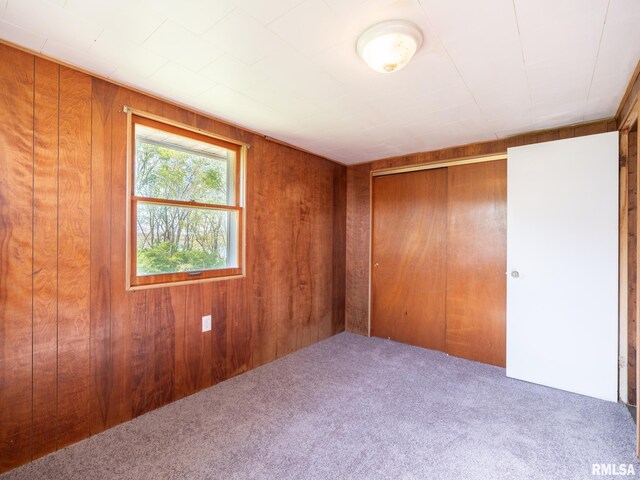 empty room with wood walls and carpet floors