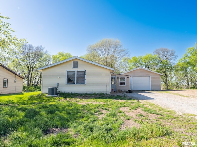 ranch-style house featuring a detached garage, an outbuilding, central AC unit, and driveway