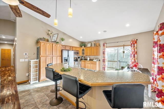 kitchen with recessed lighting, hanging light fixtures, stainless steel appliances, a kitchen bar, and baseboards
