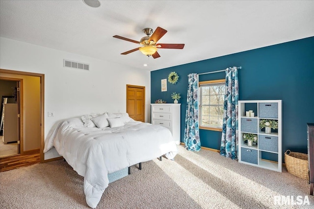 bedroom with carpet flooring, a ceiling fan, visible vents, and baseboards
