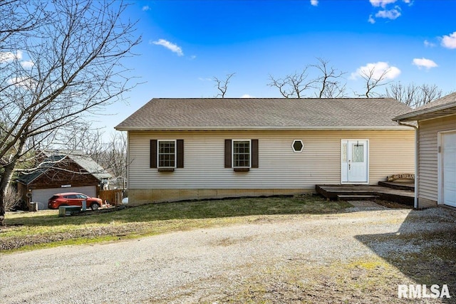 exterior space with driveway and a shingled roof