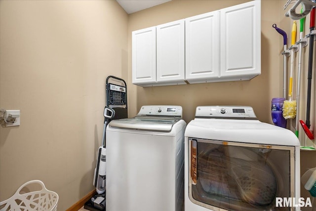 laundry area with cabinet space, baseboards, and washer and clothes dryer