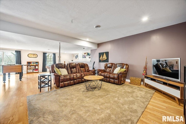 living area with recessed lighting, a textured ceiling, and wood finished floors