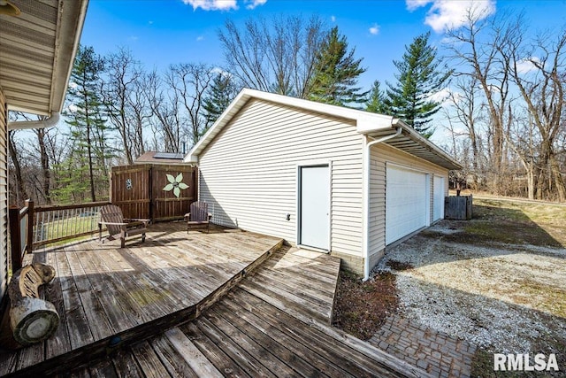 deck with an outdoor structure and a detached garage