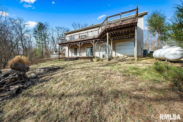 view of front of home featuring a garage, a wooden deck, and a front lawn