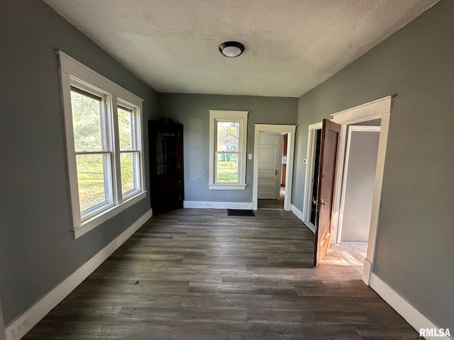 921 W Brons Ave, Peoria, IL 61604 - unfurnished dining area with a textured ceiling, dark wood-style floors, and baseboards