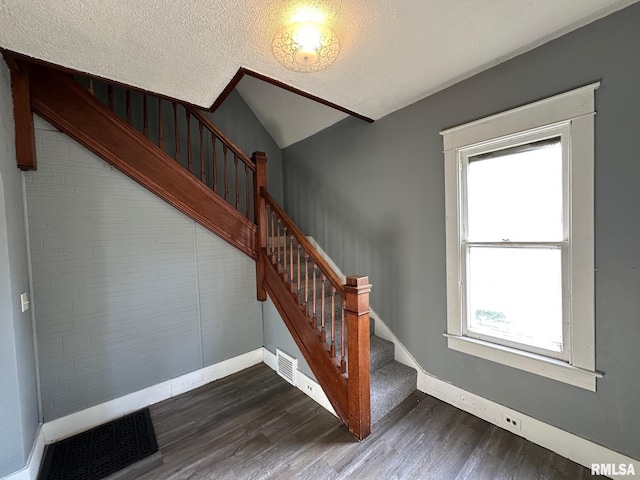 921 W Brons Ave, Peoria, IL 61604 - staircase featuring wood finished floors, visible vents, baseboards, a textured ceiling, and lofted ceiling