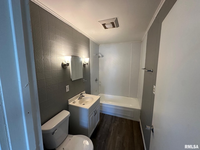 921 W Brons Ave, Peoria, IL 61604 - full bath with shower / bathtub combination, toilet, tile walls, wood finished floors, and vanity