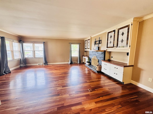711 E Piper St, Macomb, IL 61455 - unfurnished living room with ornamental molding, plenty of natural light, wood finished floors, a stone fireplace, and baseboards