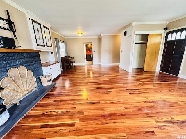 711 E Piper St, Macomb, IL 61455 - unfurnished living room with light wood-type flooring, ornamental molding, and baseboards