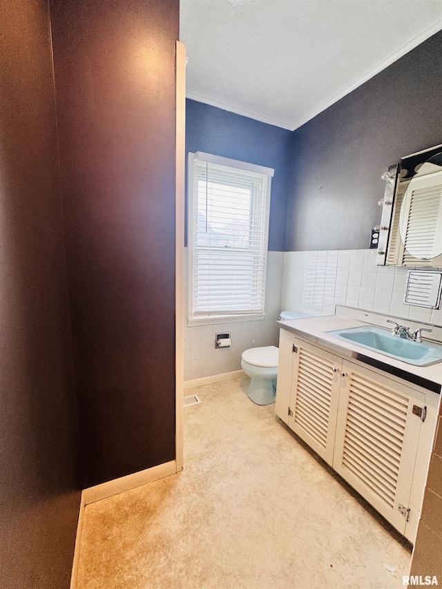 711 E Piper St, Macomb, IL 61455 - bathroom featuring crown molding, toilet, vanity, and tile walls