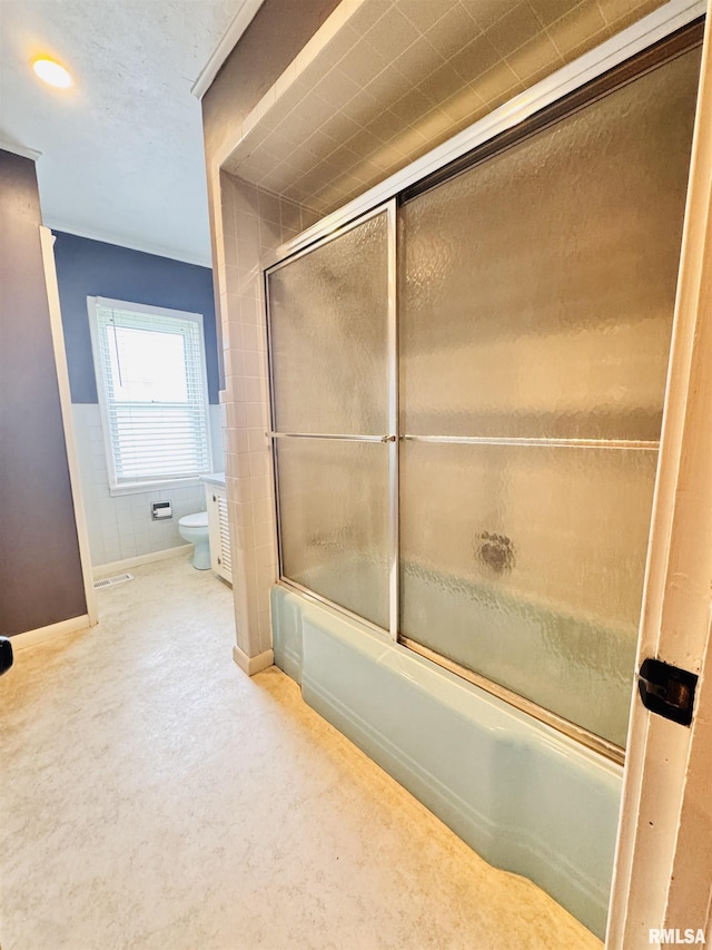 711 E Piper St, Macomb, IL 61455 - bathroom featuring toilet, enclosed tub / shower combo, and baseboards