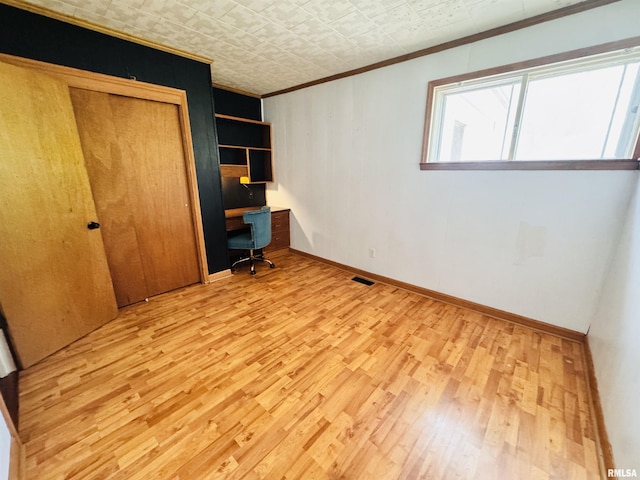 711 E Piper St, Macomb, IL 61455 - unfurnished bedroom with ornamental molding, light wood finished floors, baseboards, and a closet