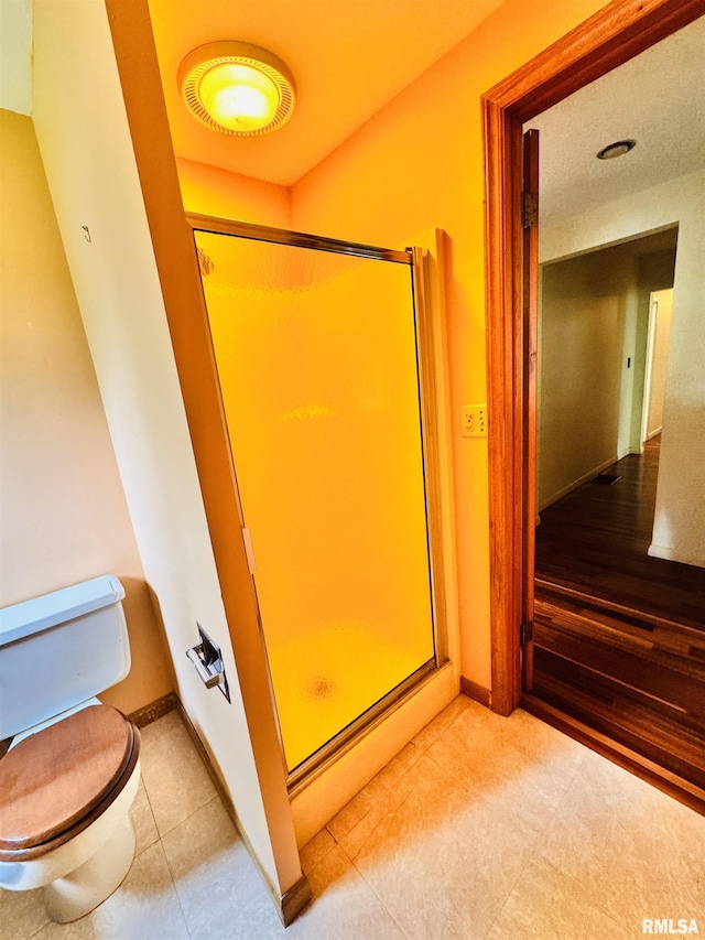 711 E Piper St, Macomb, IL 61455 - bathroom featuring toilet, a stall shower, and baseboards