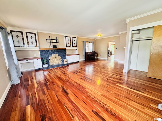 711 E Piper St, Macomb, IL 61455 - unfurnished living room featuring wood finished floors, crown molding, and baseboards