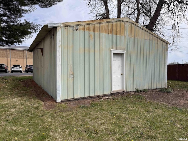 view of outdoor structure featuring fence and an outbuilding
