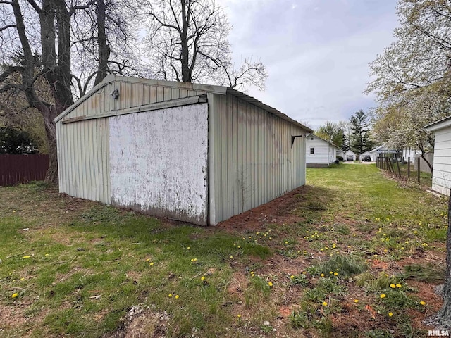 view of outbuilding featuring fence and an outbuilding