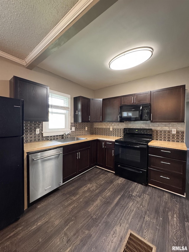 kitchen with dark brown cabinets, light countertops, tasteful backsplash, a sink, and black appliances