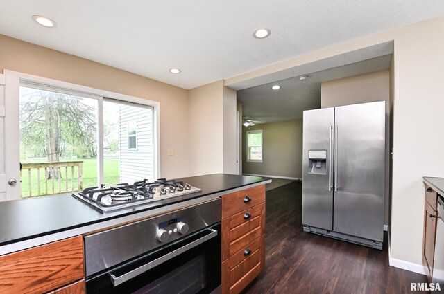 kitchen with recessed lighting, stainless steel appliances, brown cabinets, and dark wood-style floors