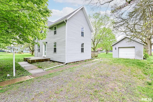 view of home's exterior featuring a yard, an outdoor structure, a detached garage, and a wooden deck