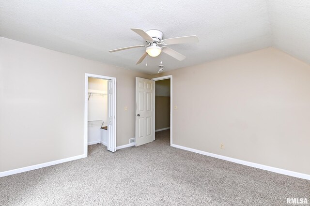 unfurnished bedroom featuring a closet, baseboards, ceiling fan, light carpet, and a spacious closet