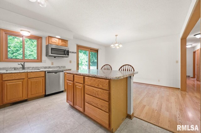 25633 N County Road 2500 E, Manito, IL 61546 - kitchen with stainless steel appliances, a sink, a chandelier, a kitchen island, and decorative light fixtures