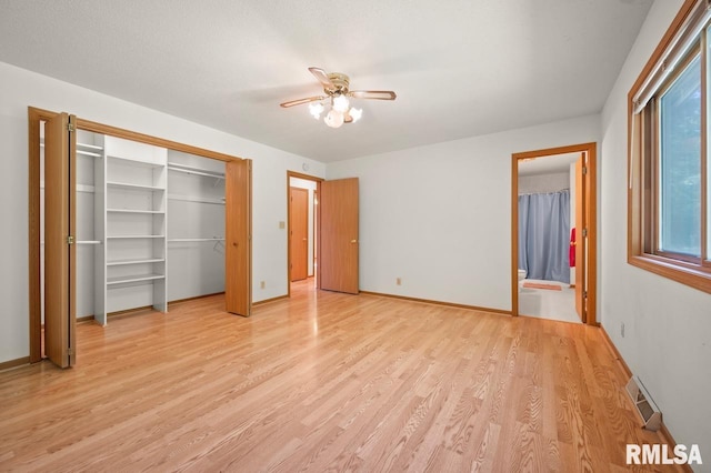 25633 N County Road 2500 E, Manito, IL 61546 - unfurnished bedroom featuring light wood-type flooring, baseboards, connected bathroom, and a ceiling fan
