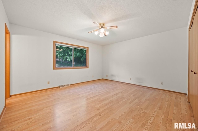 25633 N County Road 2500 E, Manito, IL 61546 - empty room featuring a ceiling fan, light wood-style floors, a textured ceiling, and baseboards