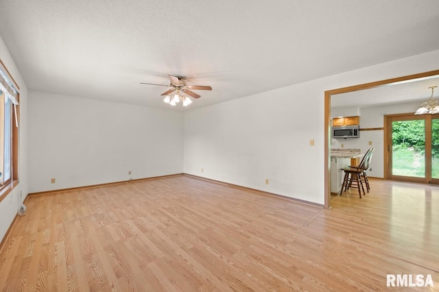 25633 N County Road 2500 E, Manito, IL 61546 - unfurnished room featuring light wood-style floors, ceiling fan, baseboards, and a chandelier