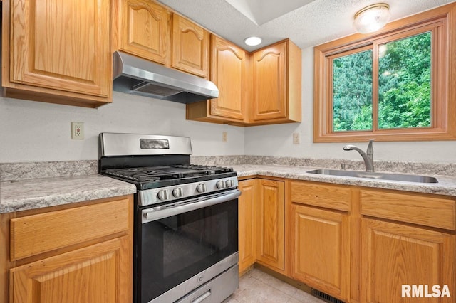 25633 N County Road 2500 E, Manito, IL 61546 - kitchen with gas range, under cabinet range hood, a sink, light countertops, and light tile patterned floors