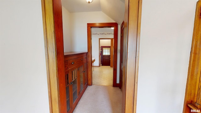 hall featuring light carpet and vaulted ceiling