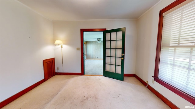 unfurnished room featuring crown molding, baseboards, and carpet