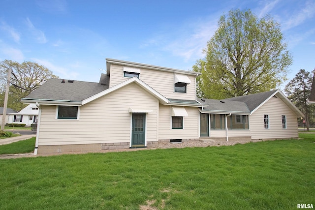 rear view of house with roof with shingles and a yard
