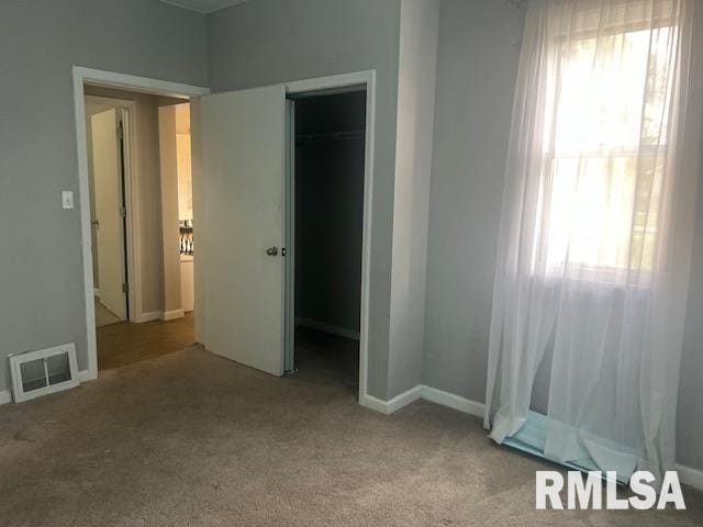 unfurnished bedroom featuring a closet, baseboards, carpet flooring, and visible vents