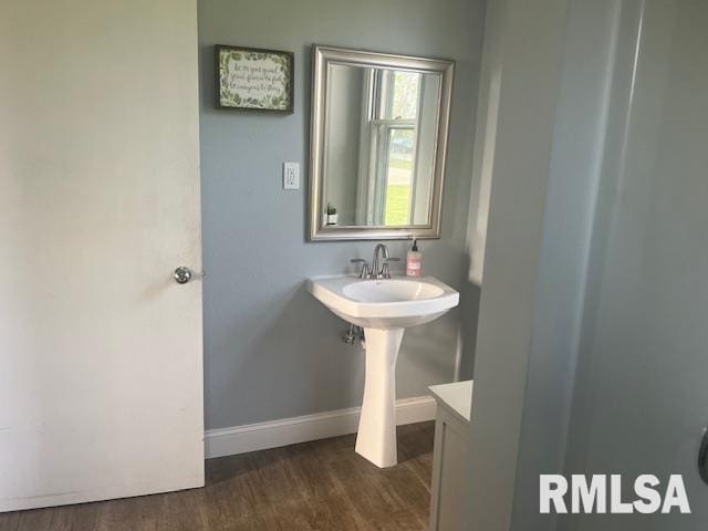 bathroom with baseboards and wood finished floors