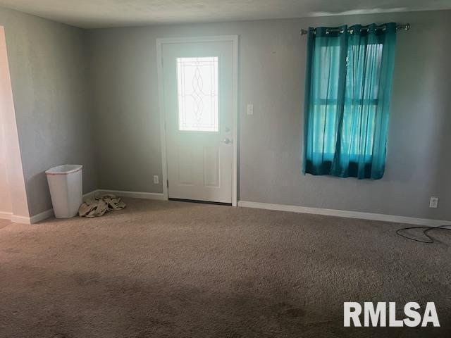 carpeted empty room with baseboards