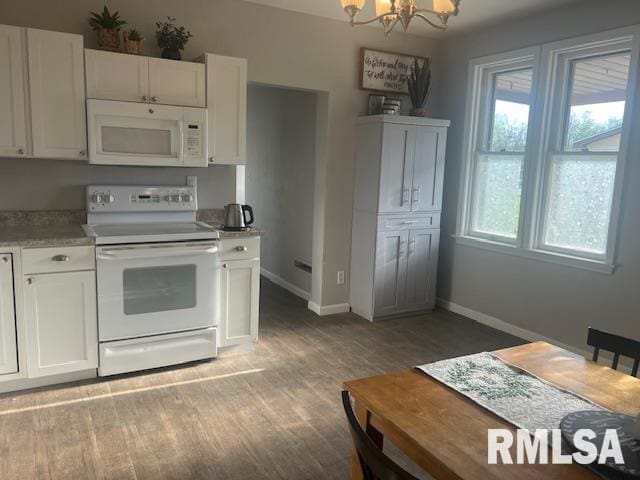 kitchen featuring a notable chandelier, light wood finished floors, white appliances, white cabinetry, and baseboards