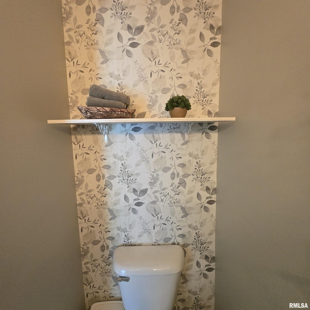 details featuring toilet and wallpapered walls