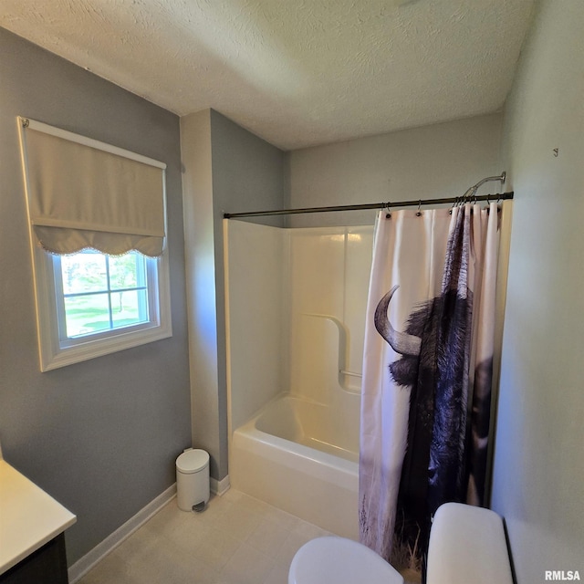 full bath with vanity, shower / tub combo with curtain, toilet, baseboards, and a textured ceiling