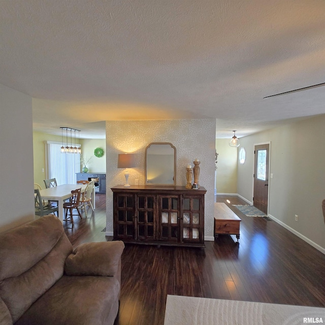 living area with a textured ceiling, baseboards, and hardwood / wood-style floors