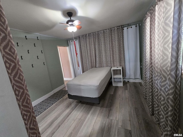 bedroom featuring baseboards, ceiling fan, and wood finished floors